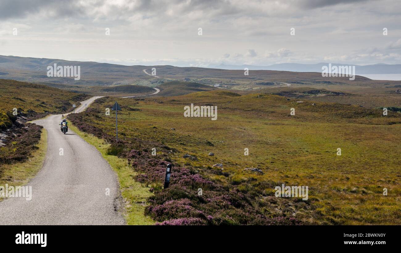 Applecross, Scotland, UK - September 24, 2013: A motorcyclist and passenger ride across moorland at Cuaig near Applecross on the North Coast 500 route Stock Photo