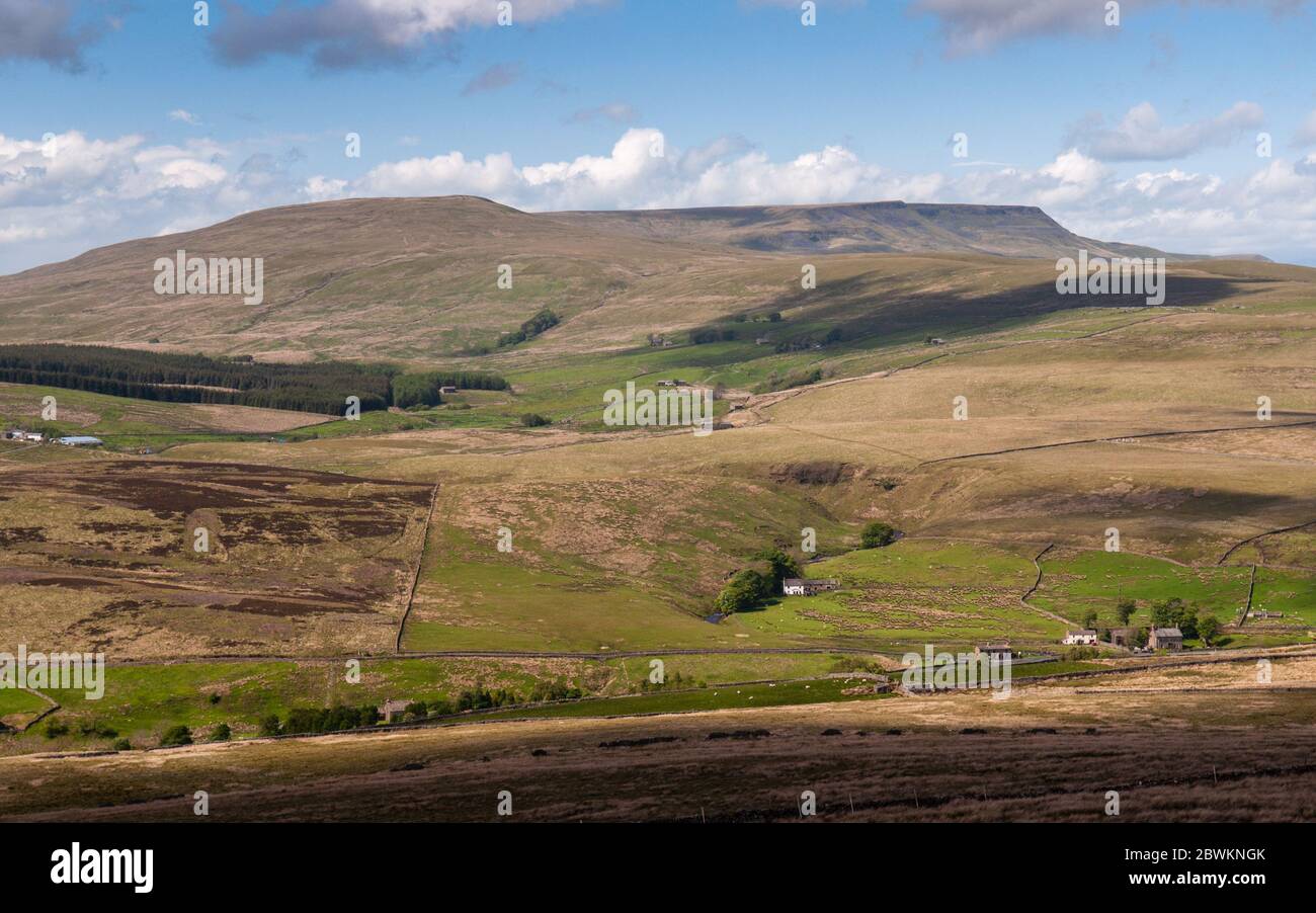 Cottages are scattered at the head of Garsdale valley under Wild Boar Fell and other moorland hills of England's Yorkshire Dales. Stock Photo