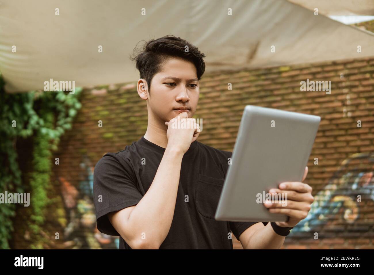 Serious young man using a tablet pc for work outdoor Stock Photo