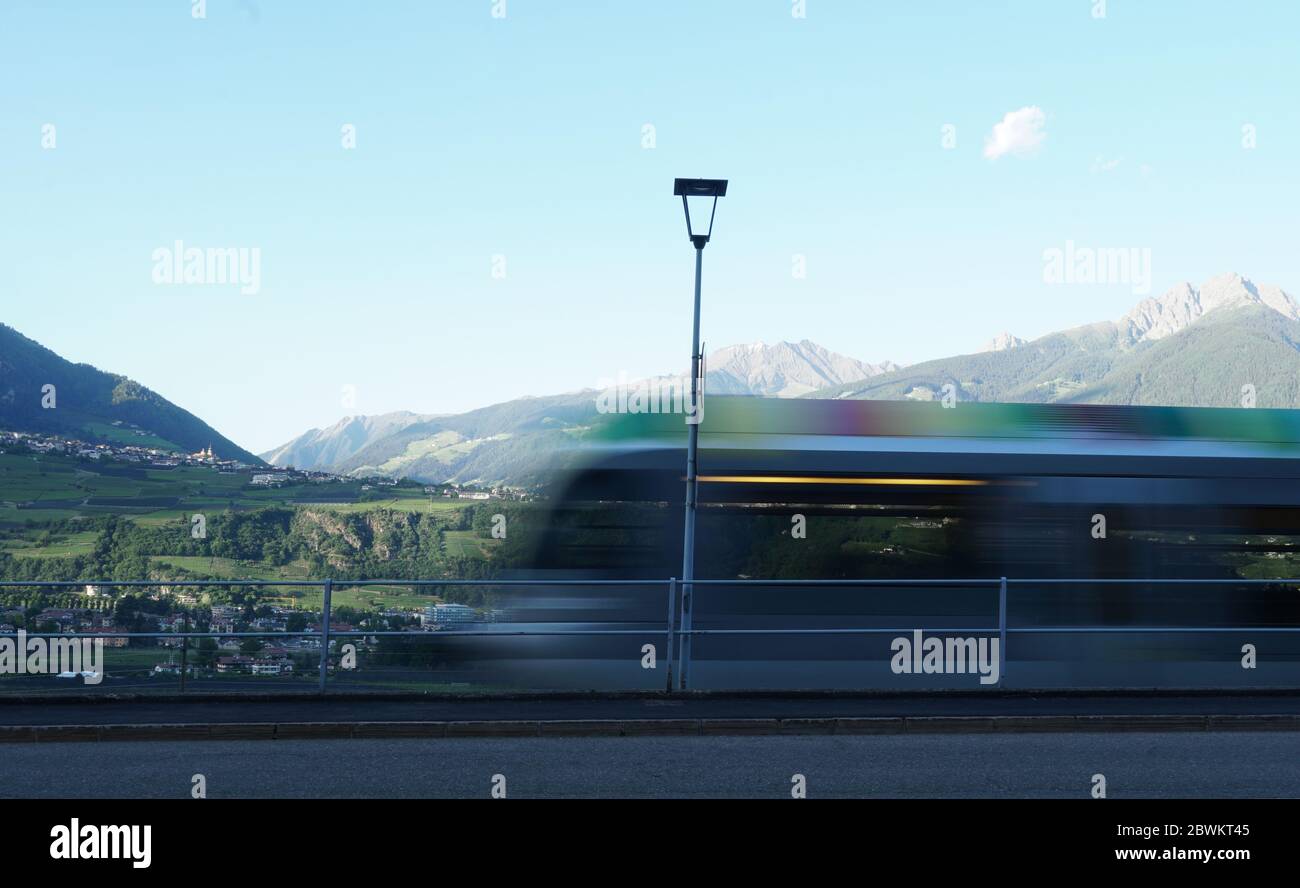 Colourful regional train blurred moving, Merano, Alto Adige, Italy. Stock Photo