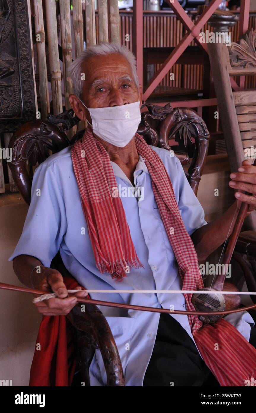 An old Cambodian man, wearing a protective face mask & krama, while