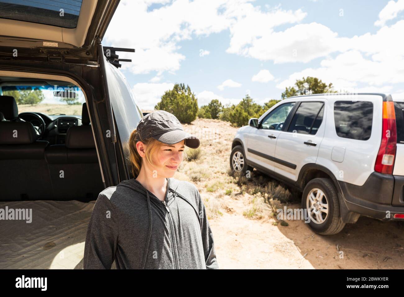 14 year old girl resting on SUV,Galisteo Basin, NM. Stock Photo