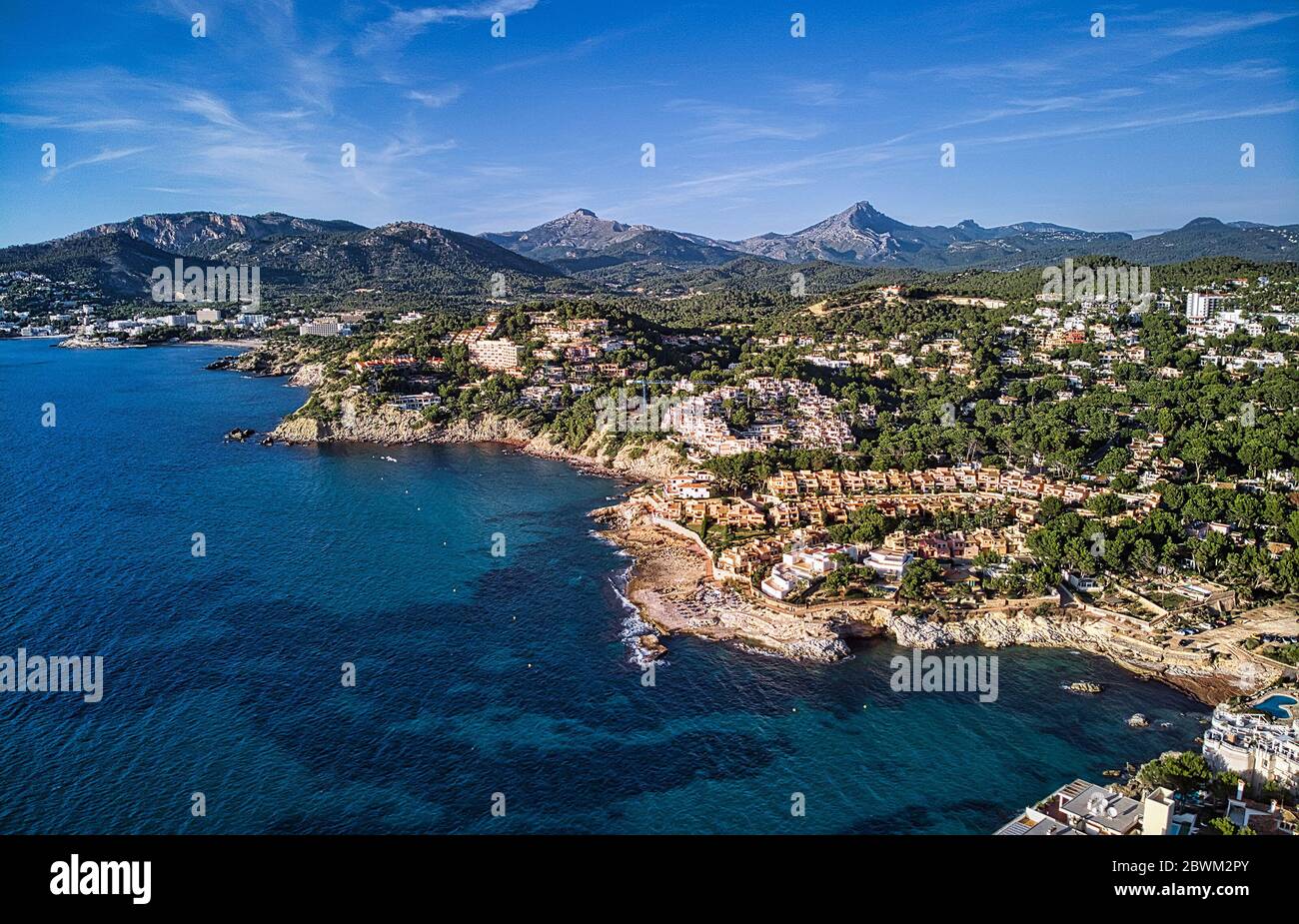 Aerial panorama of Costa de la Calma shoreline and turquoise clear green water of Mediterranean Sea. Hillside villas between pine forests. Spain Stock Photo
