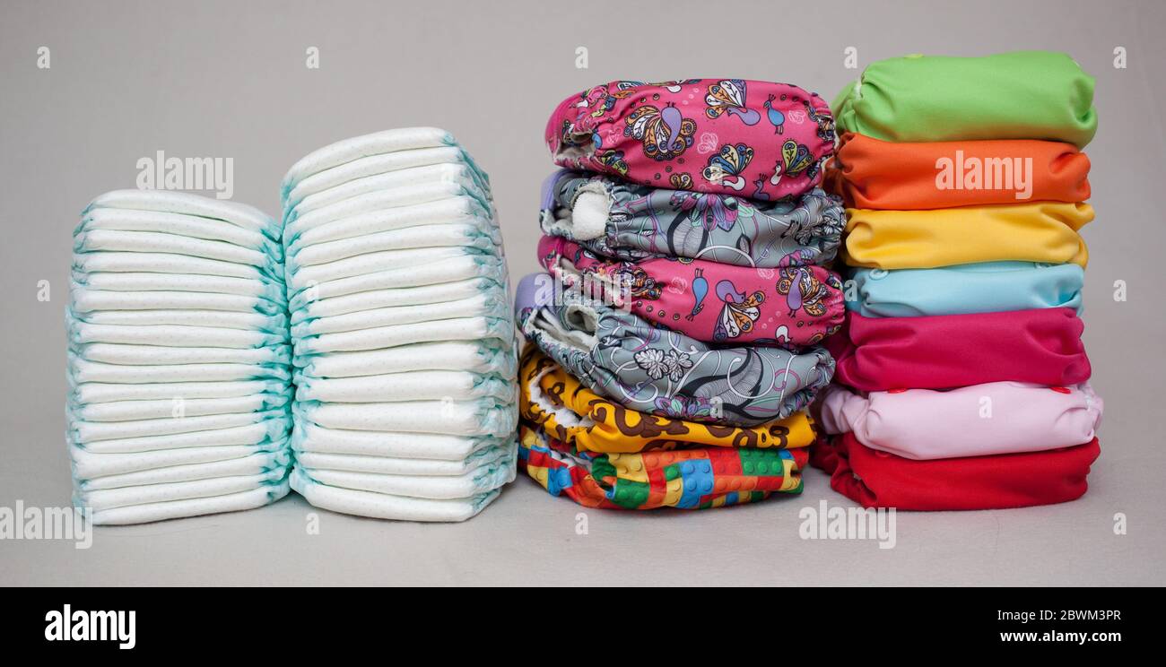 Stacks of disposable diapers and modern cloth diapers together Stock ...