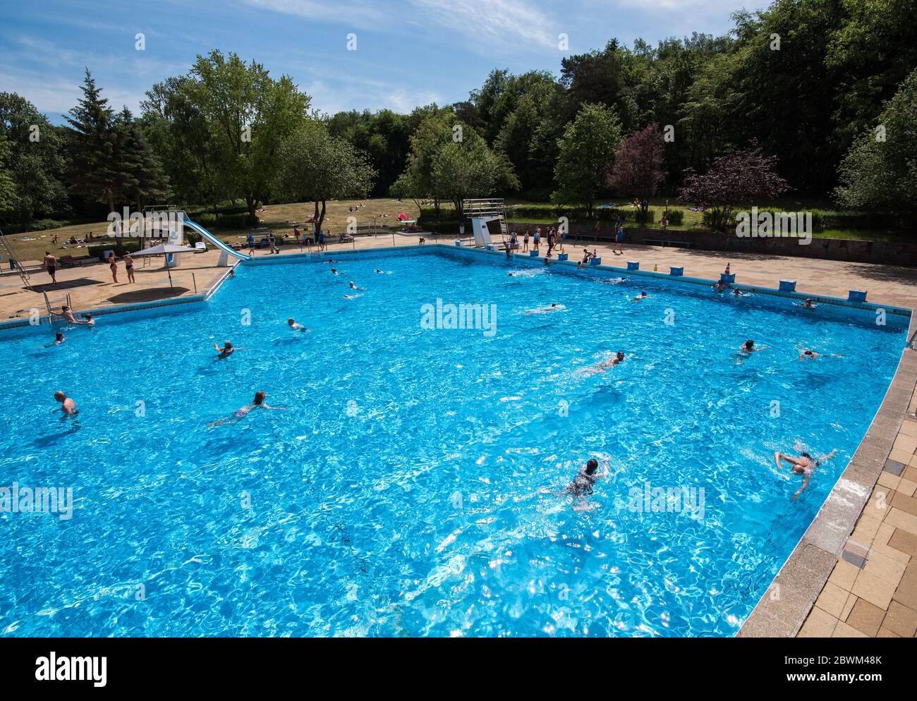 02 June 2020, Hamburg: Visitors swim in the Marienhöhe outdoor pool. With  bright sunshine and temperatures around 26 degrees Celsius, Hamburg's  open-air swimming pools were well attended on their first day of