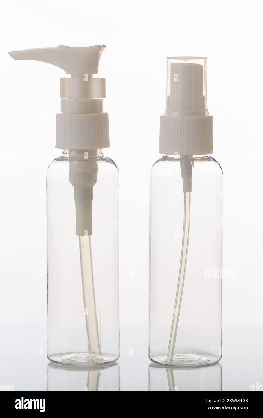 Empty transparent cosmetics bottles isolated on white background. Plastic or glass clear blank flasks with dispenser or lid. Vertical photo. Stock Photo