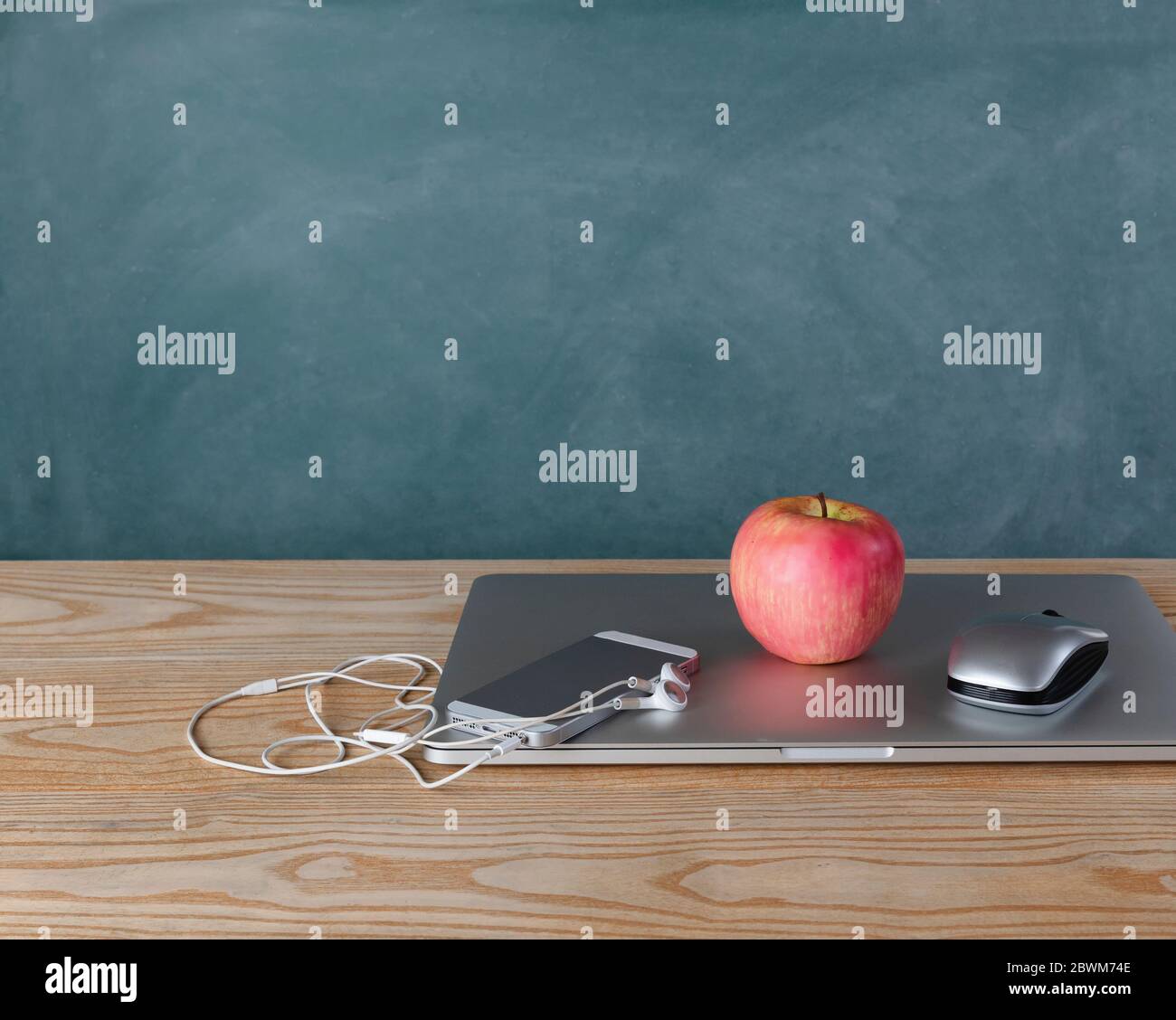 Back to school concept with basic modern technology on desktop with chalkboard in background Stock Photo