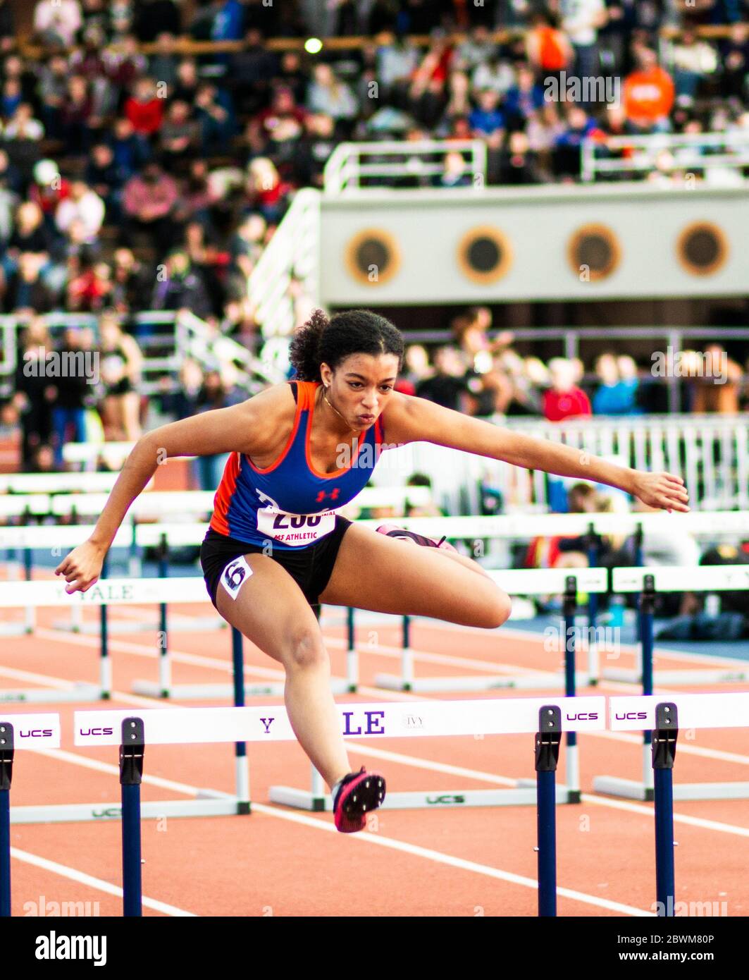 New Haven, Connecticut, USA - 12 January 2019: A female high school hurdler is racing at an indoor track meet. Stock Photo