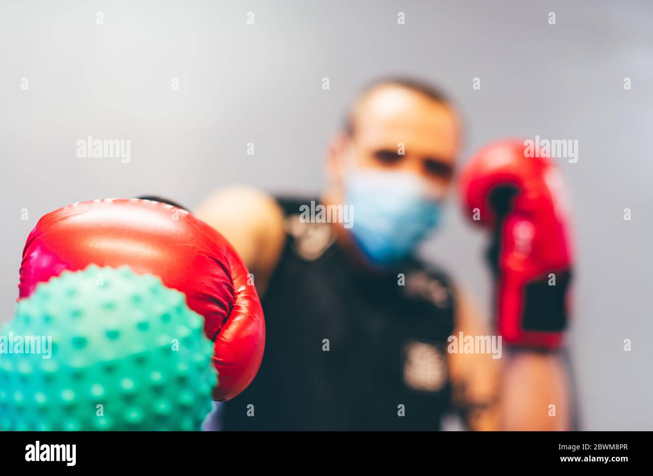 boxer with mask and red gloves fighting against coronavirus. Concept of overcoming the virus Stock Photo