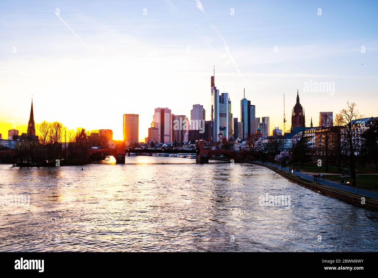 Frankfurt am Main, Germany. Skyline of Frankfurt, Germany in the sunset with famous skyscrapers and river at twilight with sun behind the skyscrapers Stock Photo