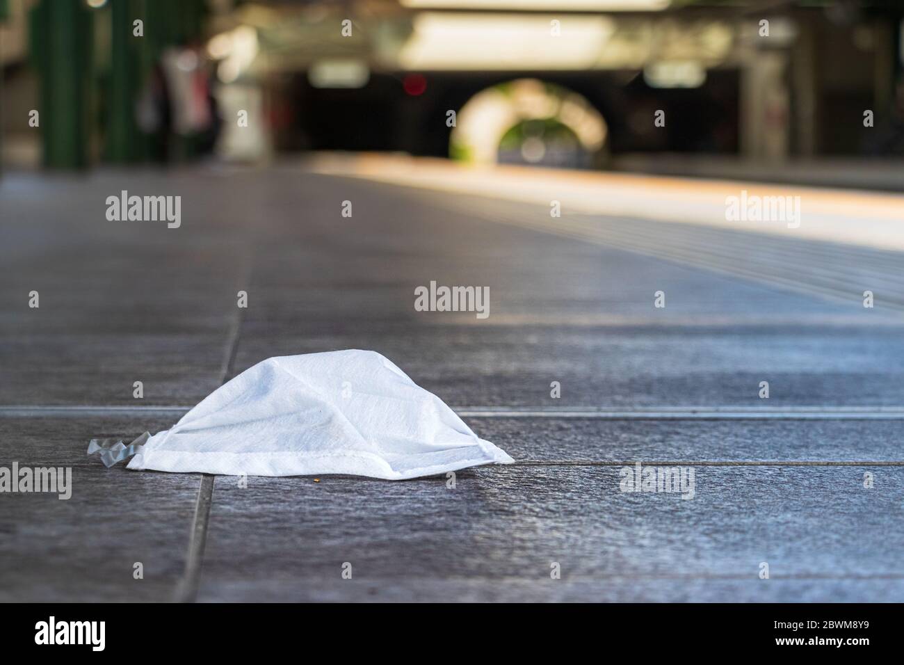 A surgical mask laying on a train station platform in Athens, Greece Stock Photo