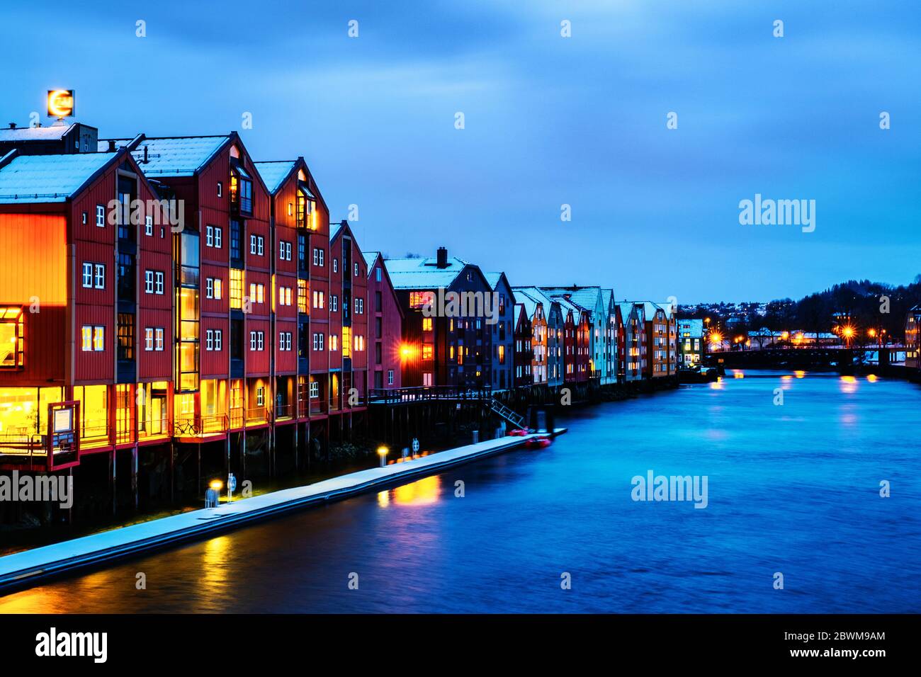 Trondheim, Norway. City center of Trondheim, Norway during the cloudy winter night. Illuminated historical colorful building and grey cloudy sky Stock Photo