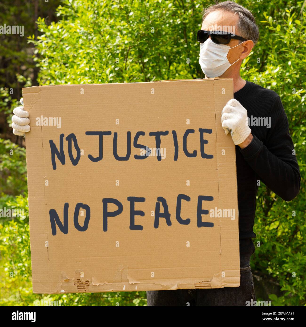 A white man holds a sign that says 'There is no justice, no peace' in protest against the murder of George Floyd. Stock Photo
