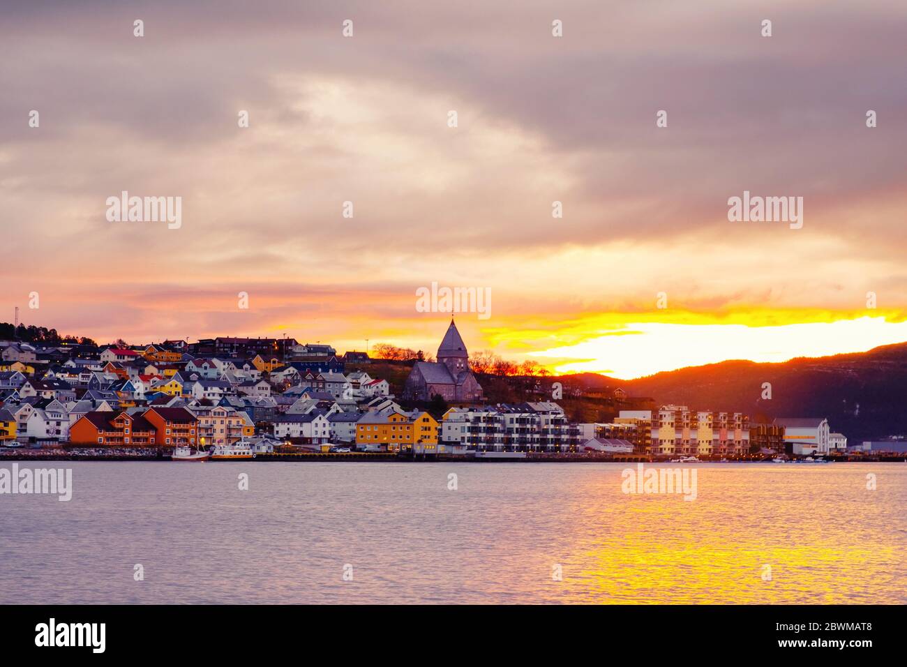 Kristiansund, Norway. View of city center of Kristiansund, Norway during the cloudy morning at sunrise with colorful sky. Port with historical buildin Stock Photo