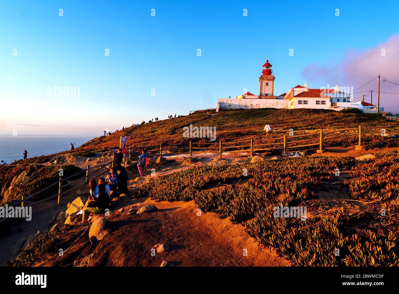 Cabo da Roca, Portugal. View of lighthouse at Cabo da Roca, Lisbon, Portugal at sunset, motion blurred people with colorful sky Stock Photo