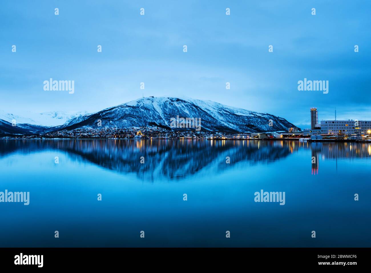 Tromso, Norway. Night view of famous north town Tromso, Norway. View of the fjord with houses and mountain, cloudy blue sky Stock Photo