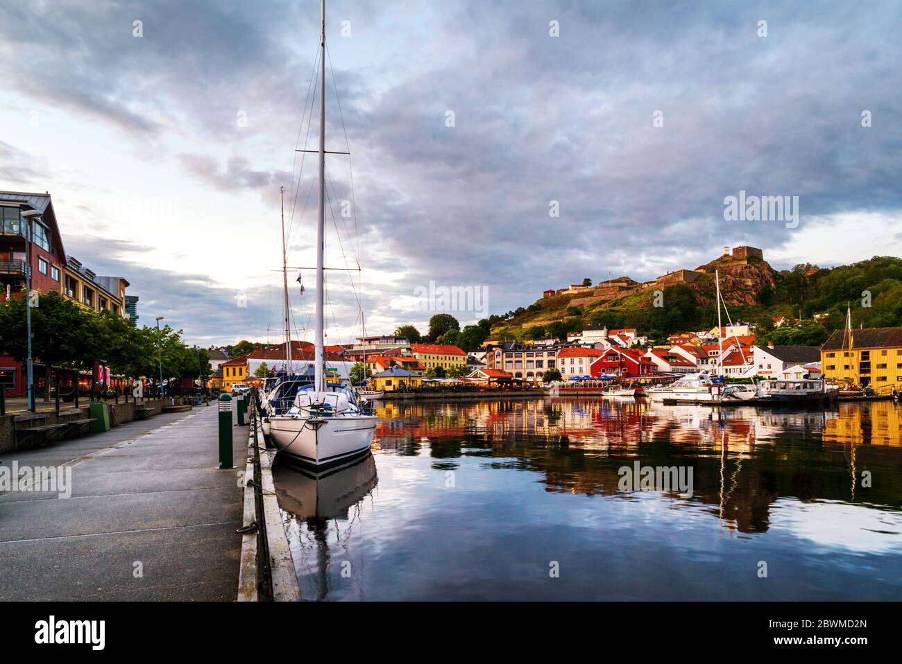Halden, Norway. View of the illuminated houses and yachts with Fredriksted fortress at the background in Halden, Norway in the evening with cloudy sun Stock Photo