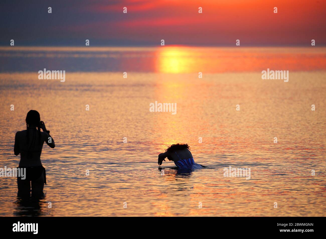 Members of the public enjoy the sun rise at Helen's bay, in Co. Down Northern Ireland, as they take a dip in the Irish Sea. Credit: Jonathan Porter/Alamy Live News Stock Photo