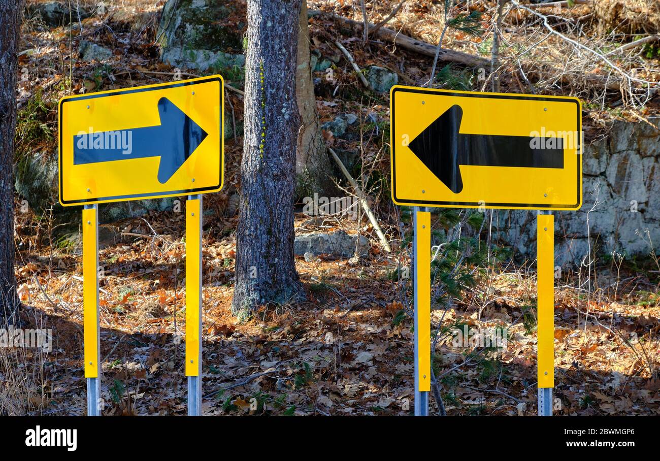 Traffic signs with directional arrows appear to invite confusion on a country road in Weston, Connecticut. Stock Photo