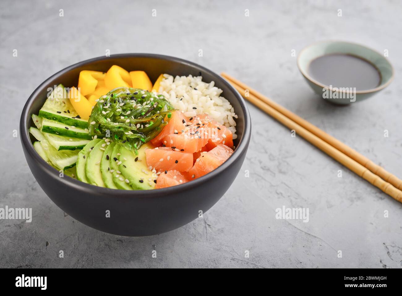 Hawaiian salmon poke bowl with seaweed, avocado, sesame seeds and