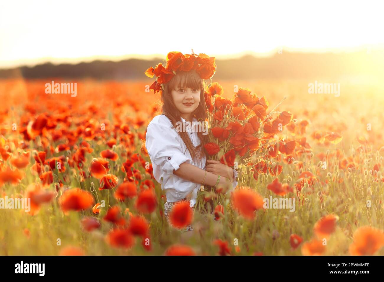 Little cute girl in white dress posing in wreath on her head with a ...