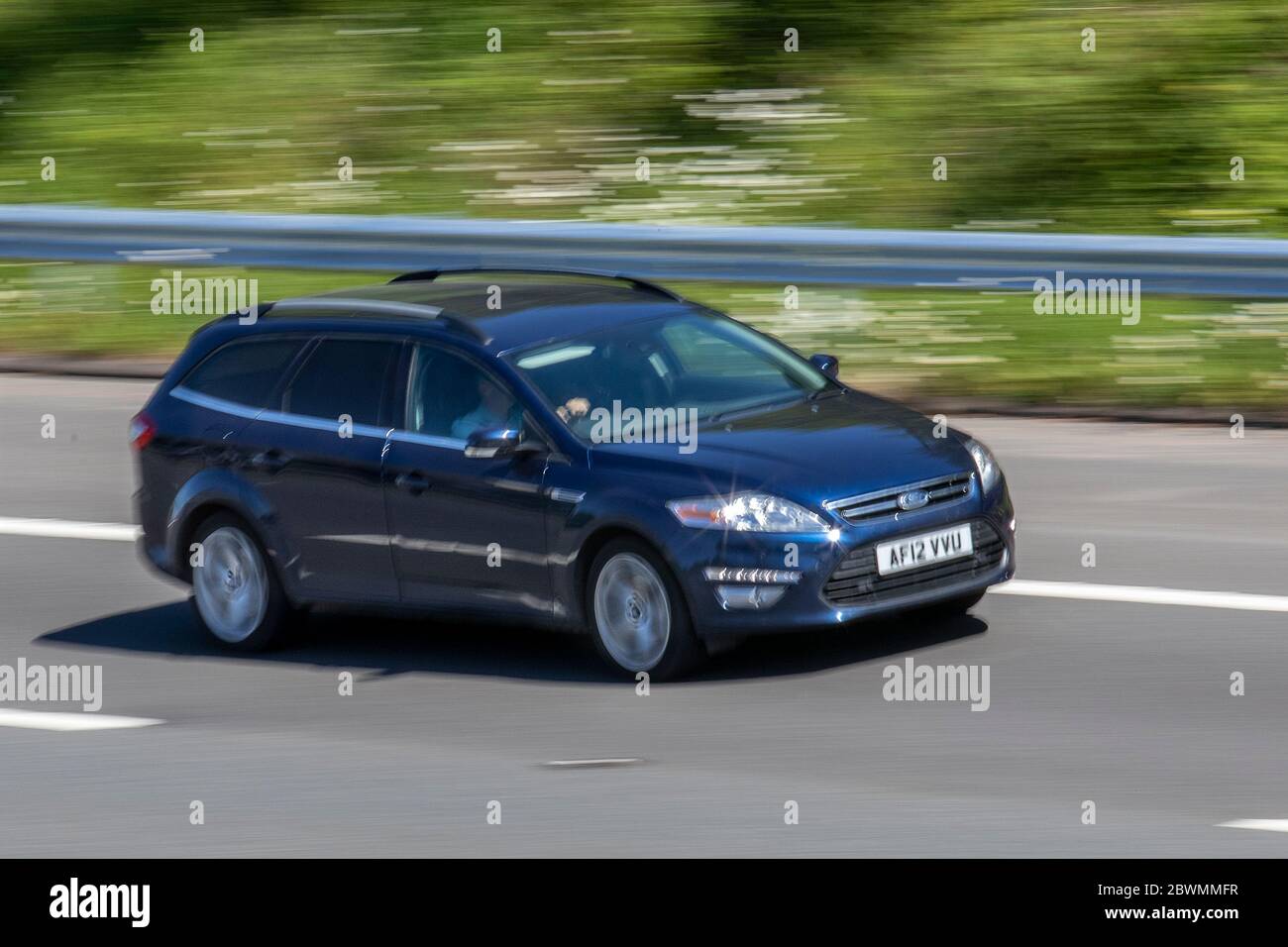 2012 blue Ford Mondeo Zetec Business EDN; Vehicular traffic moving vehicles, cars driving vehicle on UK roads, motors, motoring on the M6 motorway highway Stock Photo