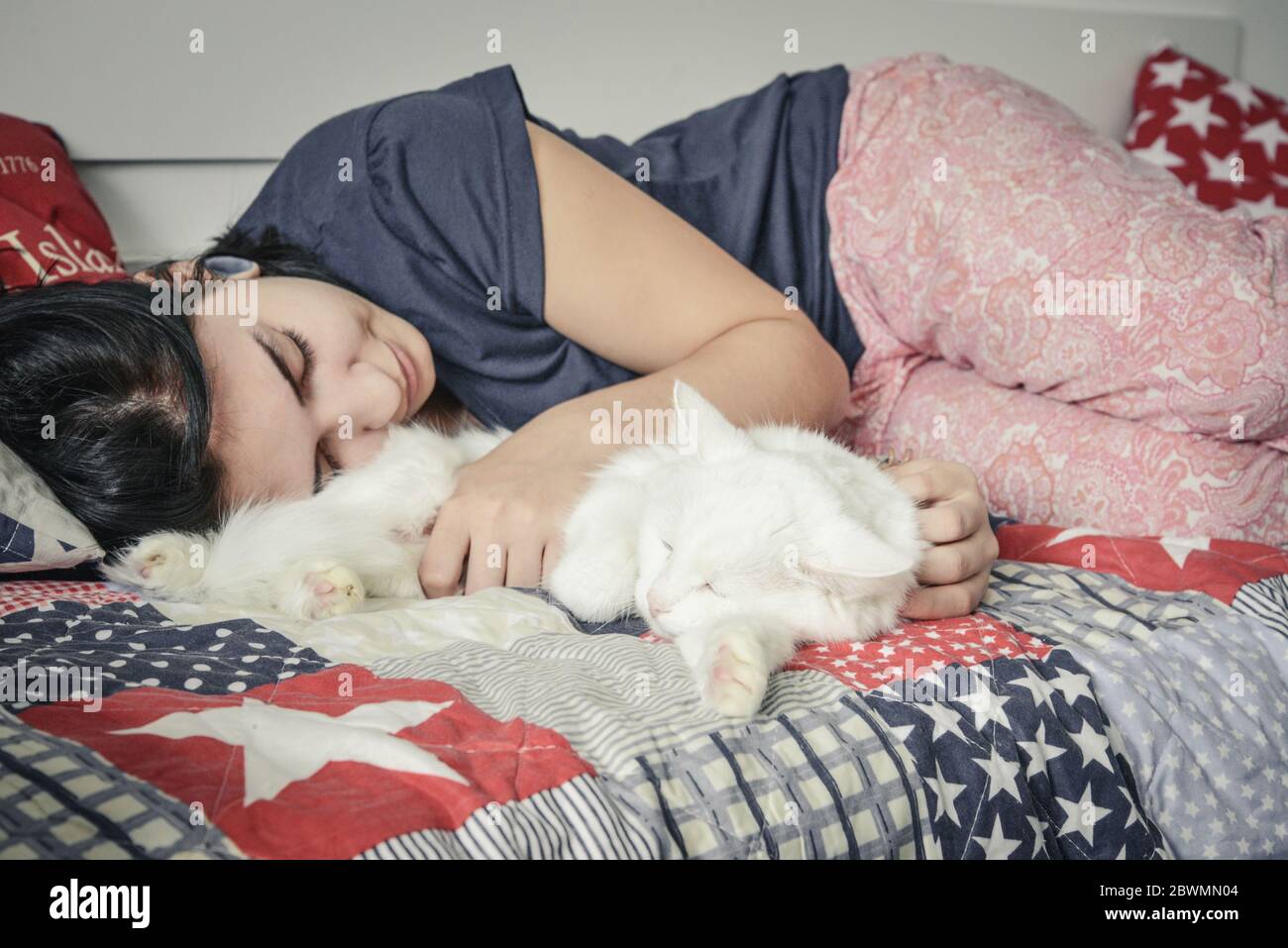 White cat and girl sleeping together on bed at home Stock Photo - Alamy