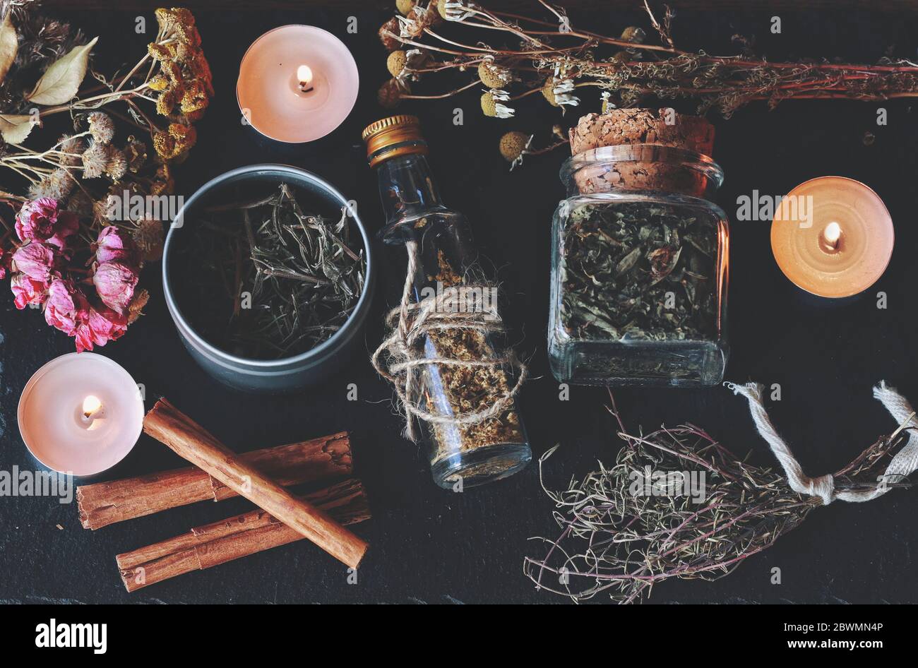 Flat lay of kitchen witchery using herbs and spices found at home. Herbal magick in wicca and witchcraft. Glass jars filled with dried herbs and spice Stock Photo