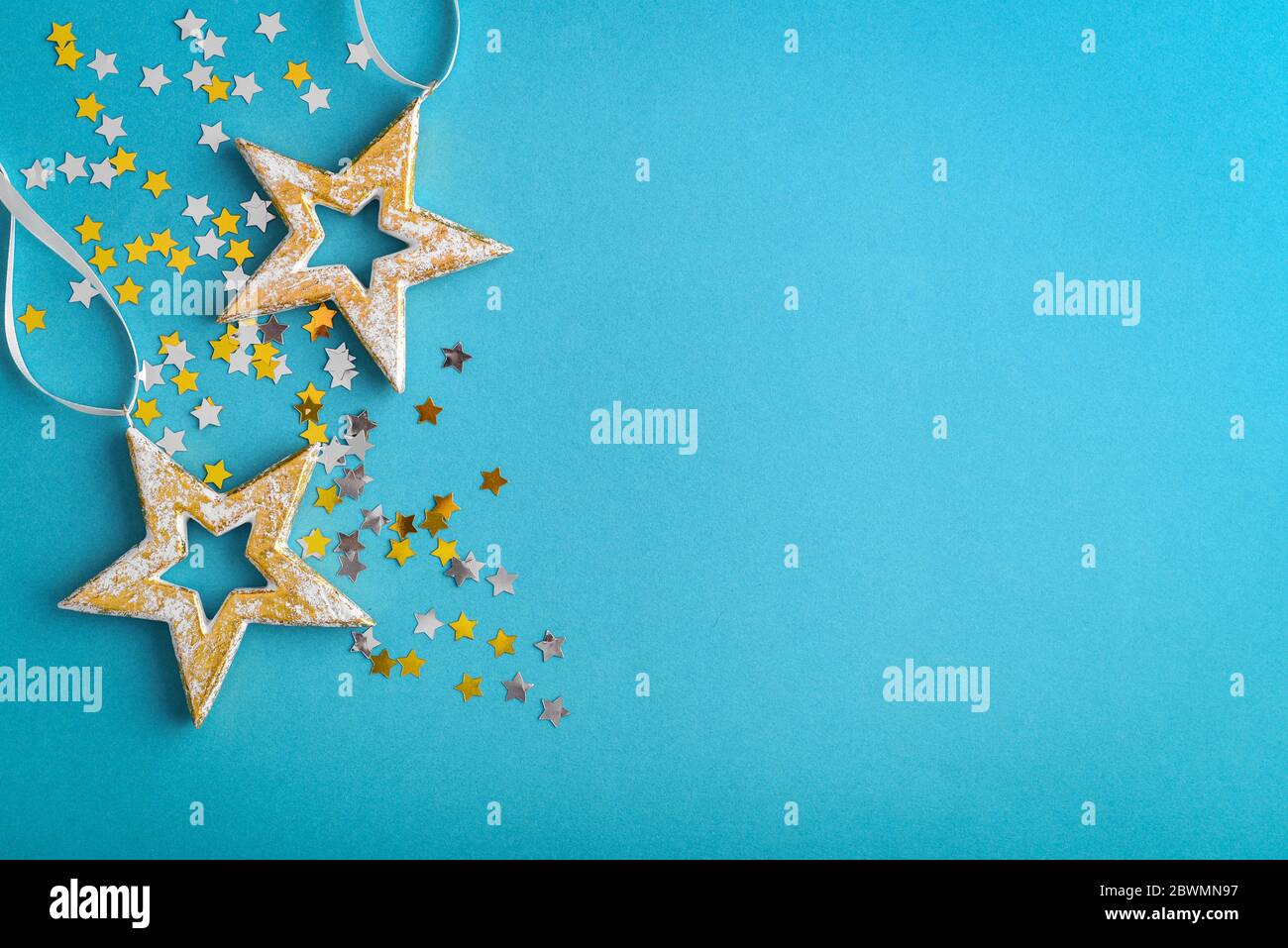 Christmas decorations in shape of stars on blue background, top view Stock Photo