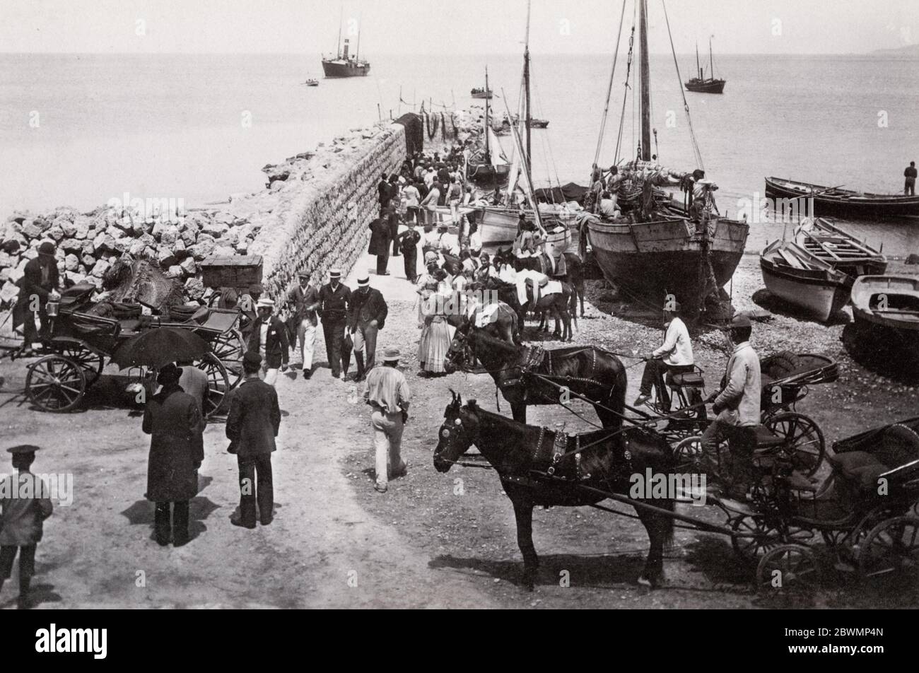 Vintage 19th century photograph - hackney carriages waiting for travellers to arrive off small boats, Capri marina, Italy. Stock Photo