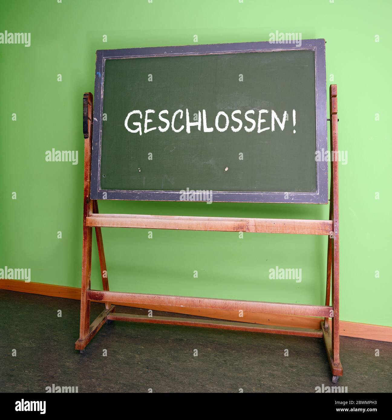 German word Geschlossen, that means Closed, on an old school chalkboard, symbolizes the closure of all schools during the risk of infection with the c Stock Photo