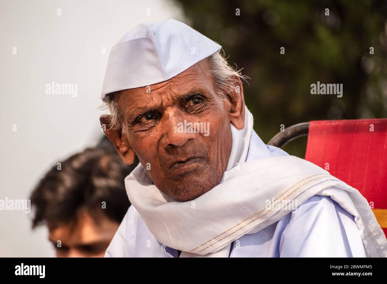 Nagpur, Maharashtra, India - March 2019: A candid close up portrait of an elderly Indian man wearing a Gandhi cap with a thoughtful expression on his Stock Photo
