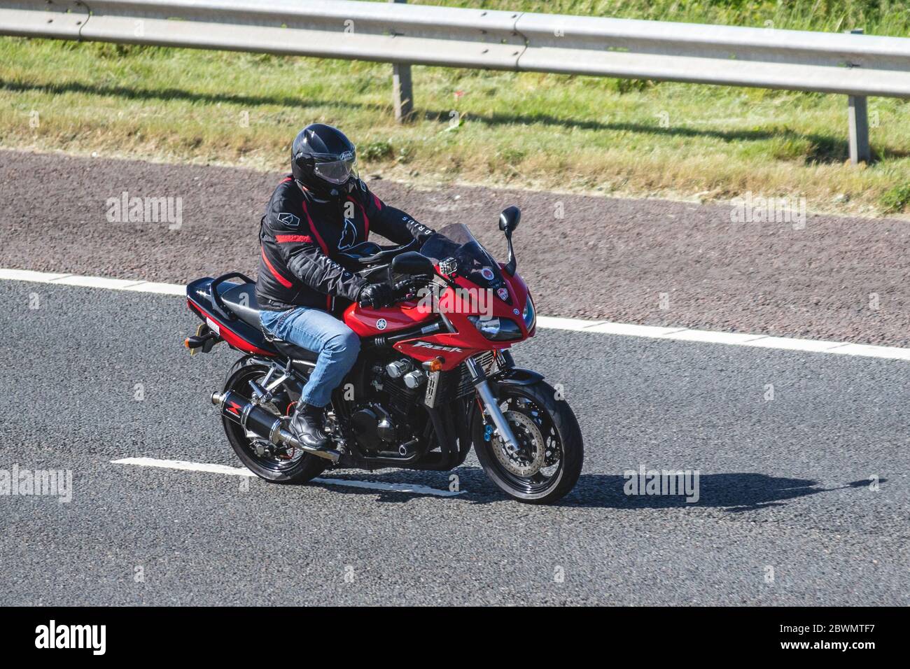Red Yamaha Fazer Motorbike rider; two wheeled transport, motorcycles, vehicle, roads, motorbikes, bike riders motoring on the M6 motorway Chorley, UK Stock Photo