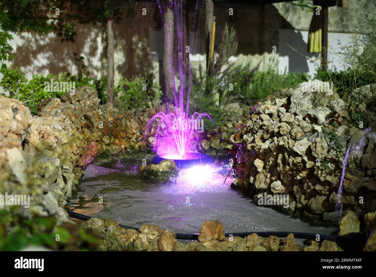 little beautiful colored water fountain at night Stock Photo - Alamy