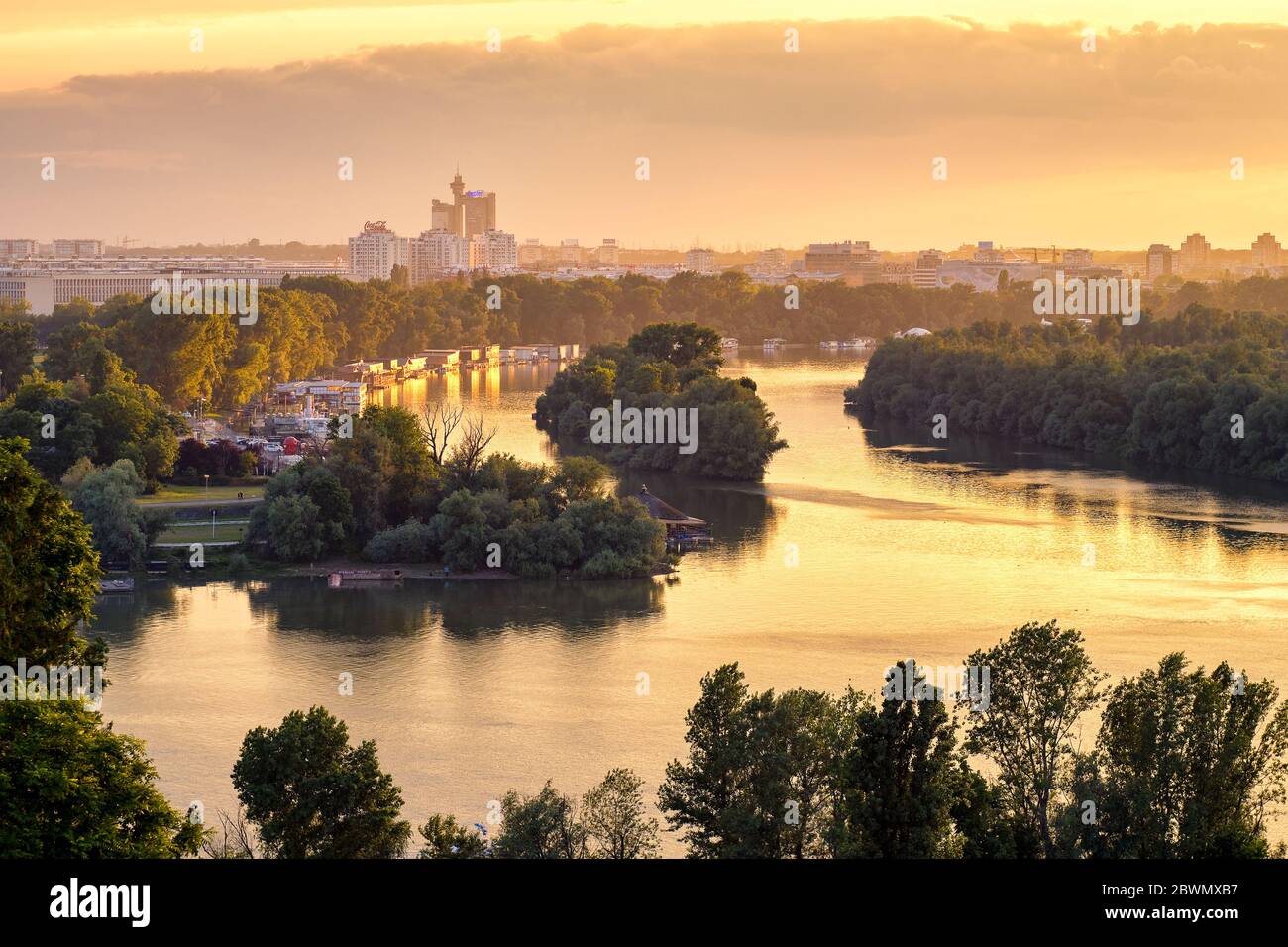 Belgrade / Serbia - May 30, 2020: Belgrade cityscape and confluence of rivers Danube and Sava at golden hour sunset, view from Belgrade Fortress Kalem Stock Photo