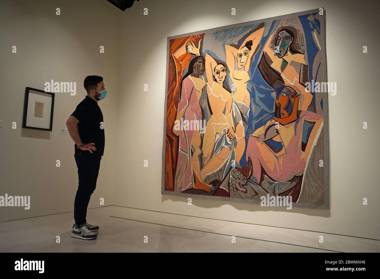 Download An Employee Wearing A Face Mask Is Seen Looking At A Painting Of The Ladies Of Avignon During The Exhibition Dialogues With Picasso Collection 2020 2023 At Picasso Museum The New Permanent Collection PSD Mockup Templates