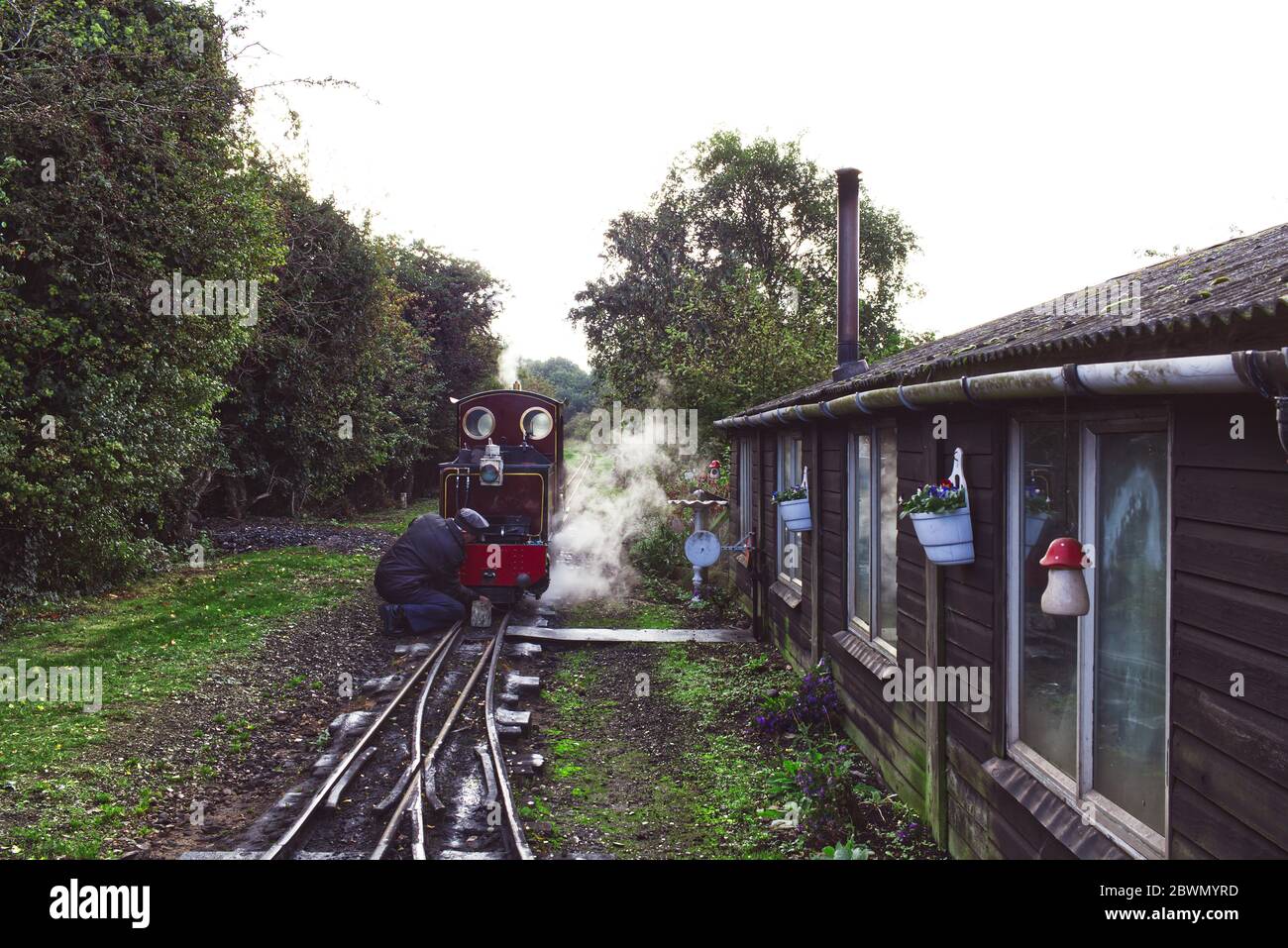 October 2019. Wells & Walsingham Light Railway, Wells-next-the-Sea, Norfolk, UK. The train driver cleans and maintains his steam locomotive Stock Photo