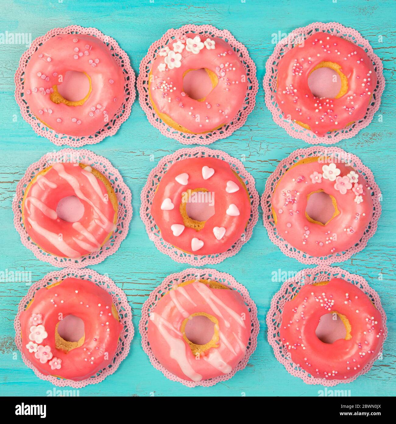 Coral colored donuts on a blue wooden background Stock Photo