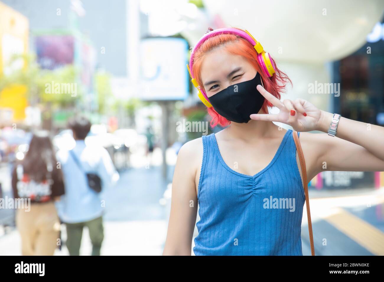 Girl teen cute punk hipster style red hair color wear face mask or face shield at outdoor public shopping walking street. Stock Photo