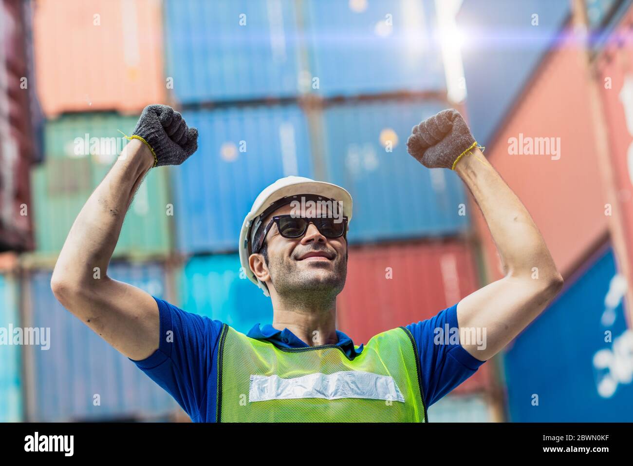 Happy Winner worker, Foreman shipping dock staff working at Container cargo harbor Rising hand for Win in Business Logistics. Stock Photo