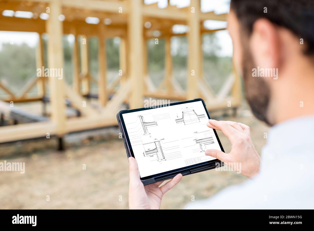 Architect or builder using digital touchpad on the construction site outdoors. Close-up on screen with copy space Stock Photo