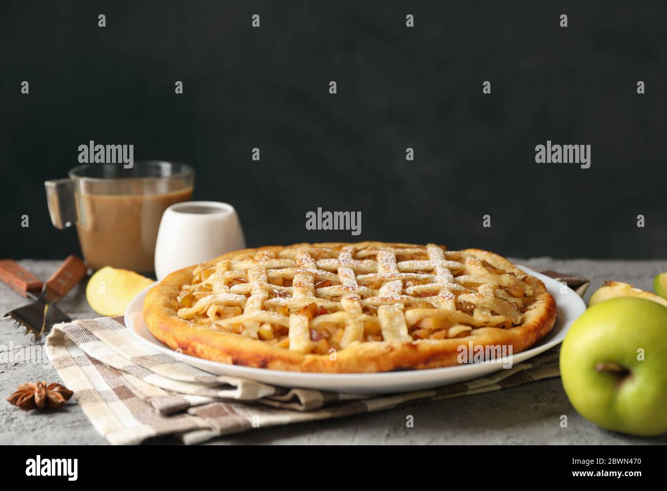 Composition with apple pie and ingredients on gray background. Homemade food Stock Photo