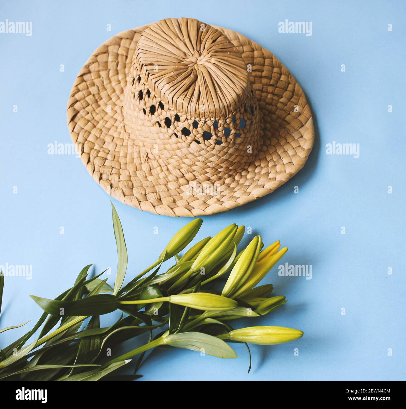 summer hat on background with yellow tulips Stock Photo