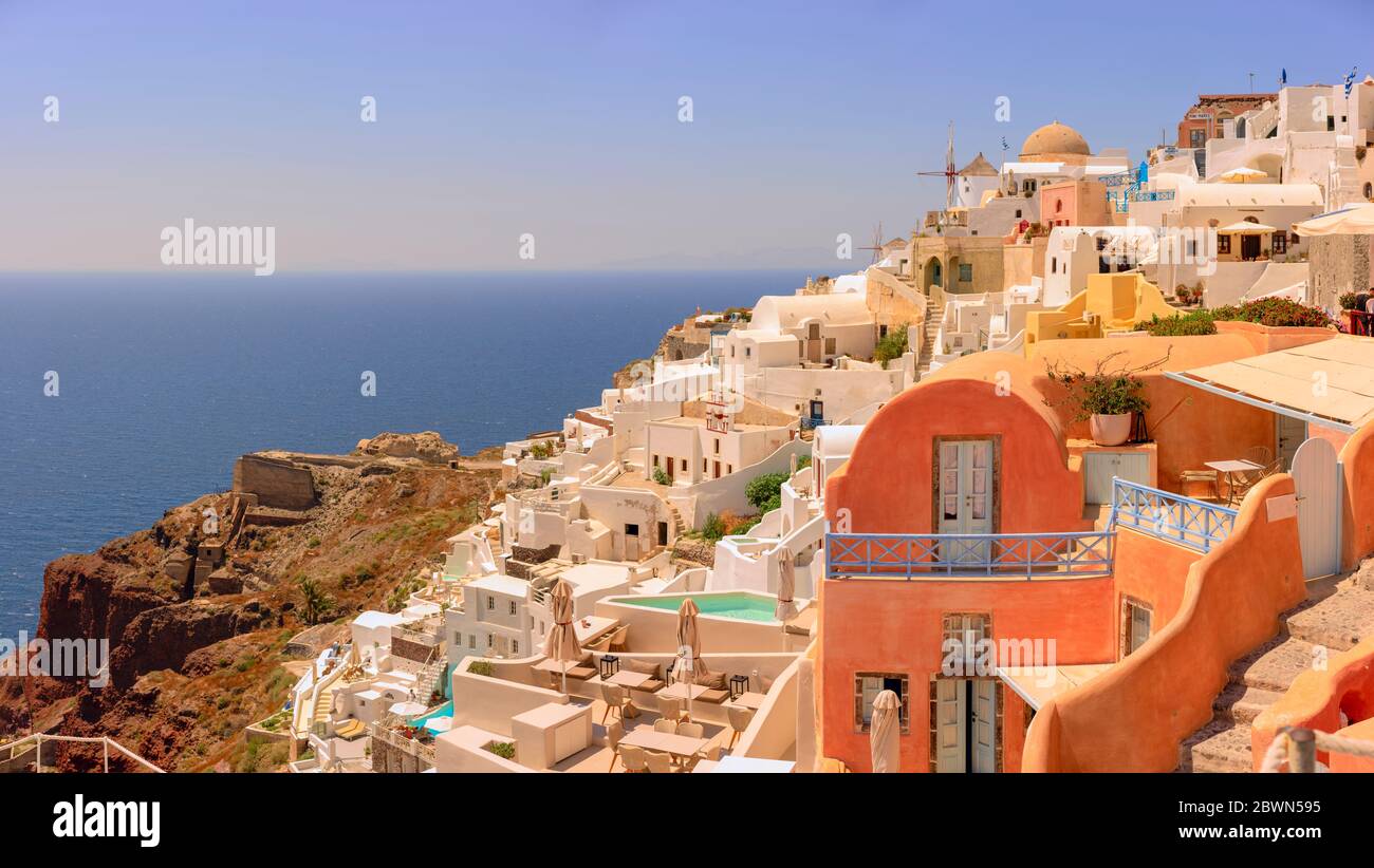 A view of Oia, a beautiful town on the greek island of Santorini, with the iconic colourful buildings built on the caldera rim of an ancient volcano. Stock Photo