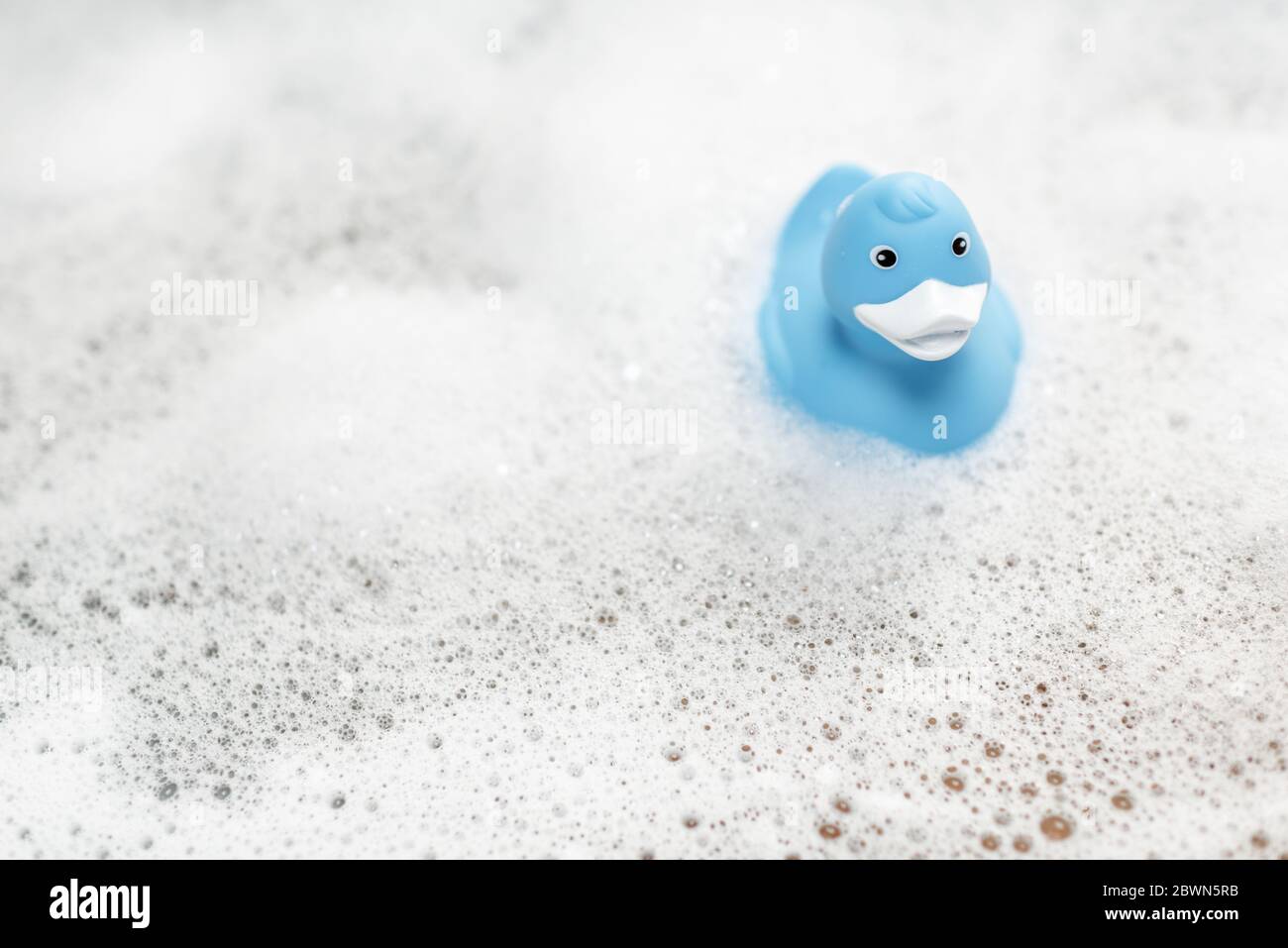 Blue rubber duck swimming in the bathtub with foam Stock Photo - Alamy