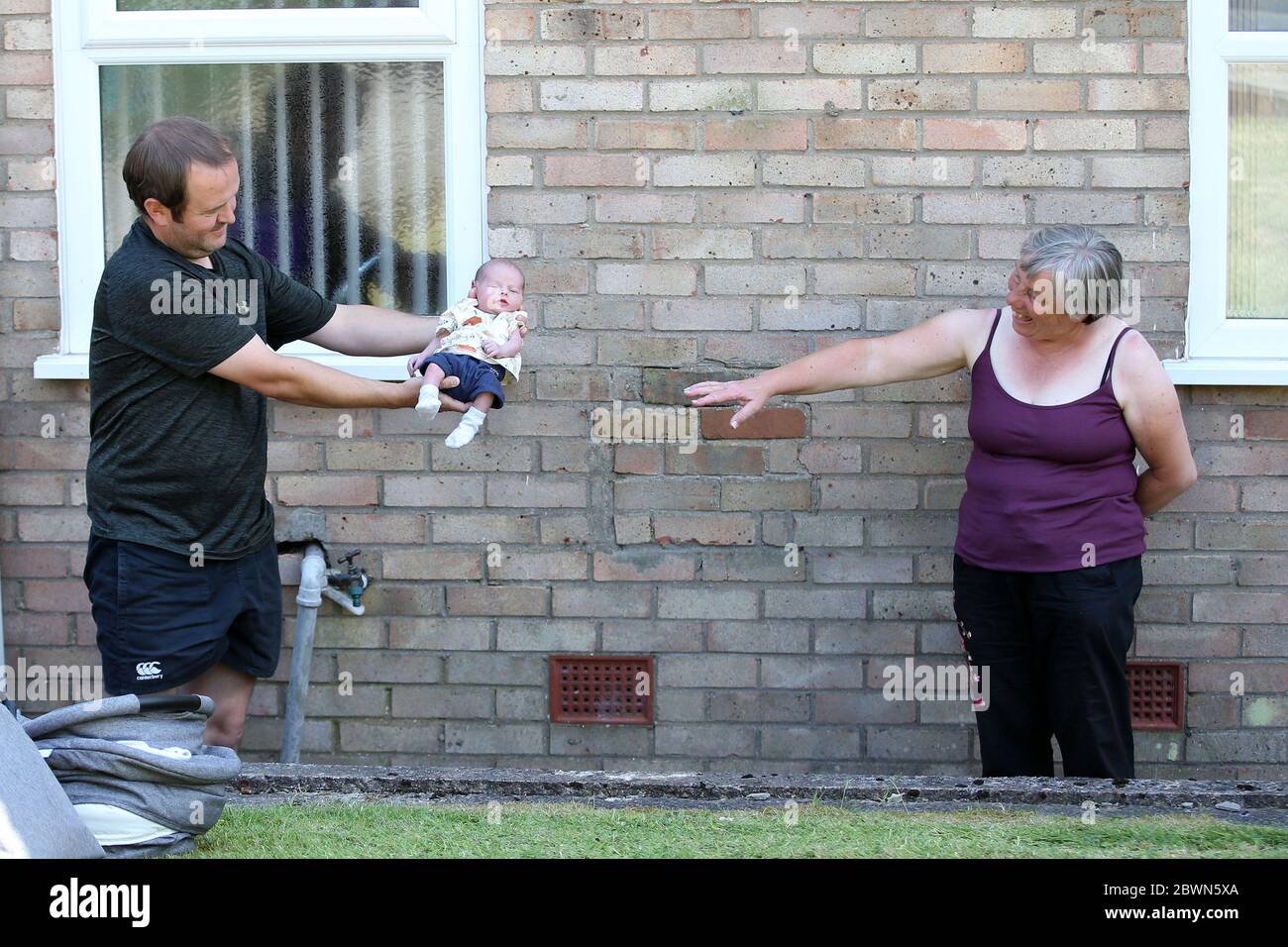 Pengam, South Wales. 02nd June, 2020. Angela Morgan (right) from Pengam, near Caerphilly, South Wales meets her 1st Grandchild Mike, born 2 weeks ago today as her son in law John (l) visit after lockdown restrictions were eased in Wales yesterday allowing families to meet up outside . pic by Andrew Orchard/Alamy Live News Stock Photo