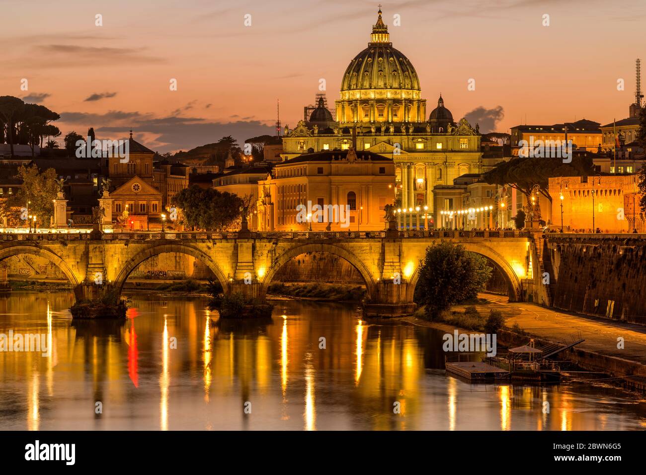 Sunset Tiber River - Colorful dusk view of Tiber river at Sant' Angelo Bridge, with St. Peter's Basilica towering in background, Rome, Italy. Stock Photo