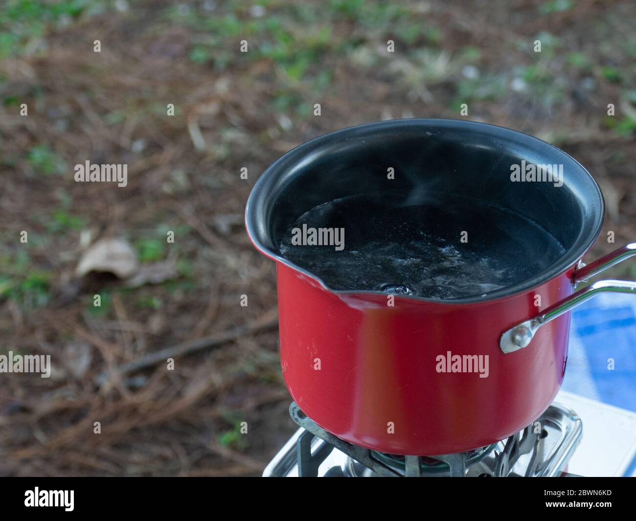 Boiling water with red pot by gas stove in campground Stock Photo Alamy