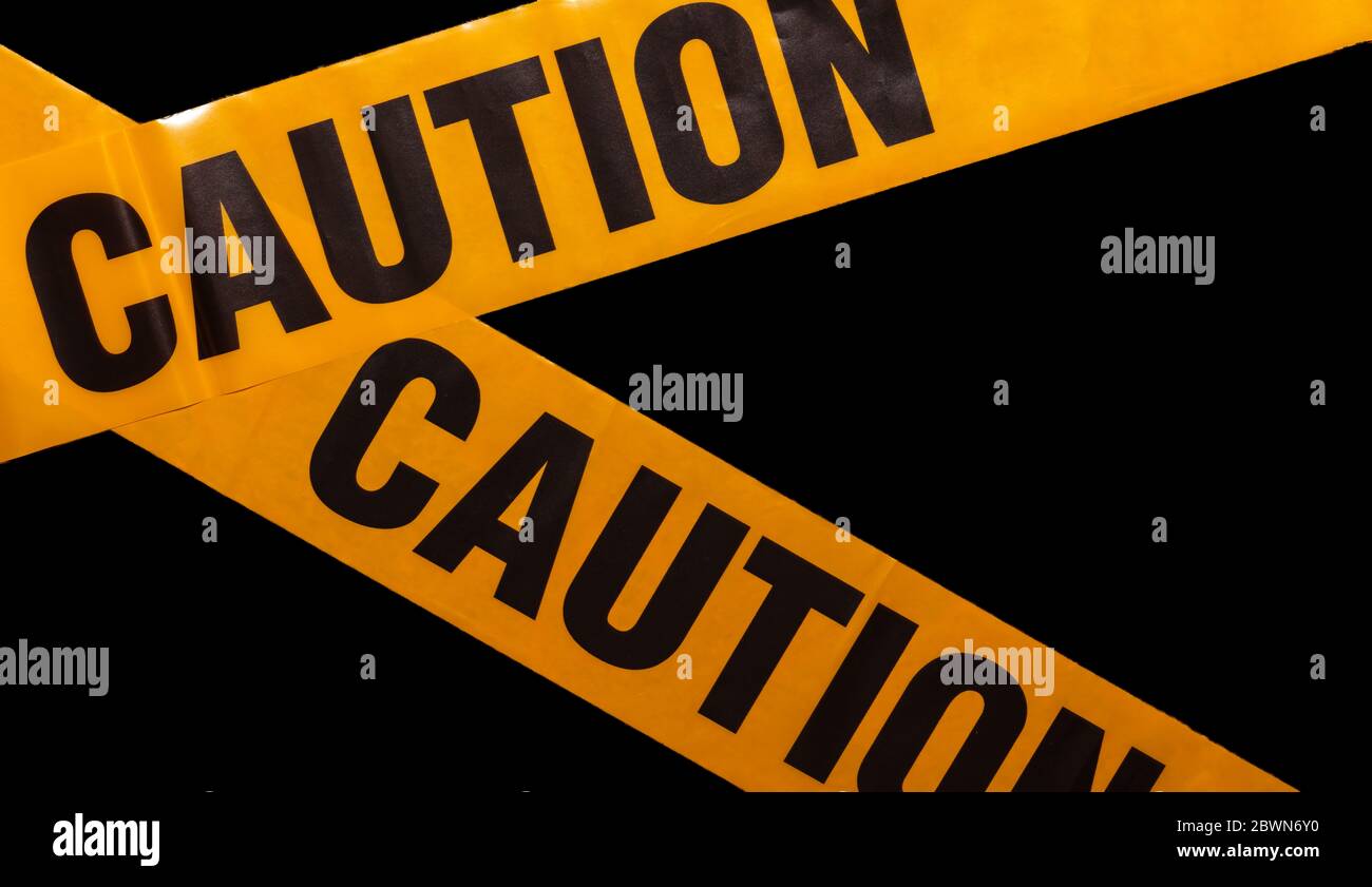 Yellow caution tapes crossing. Isolated. Black background. Protection
