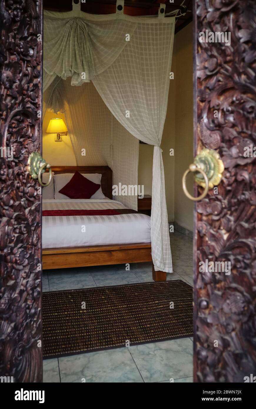 Traditional balinese bed with canopy. View through the opening of